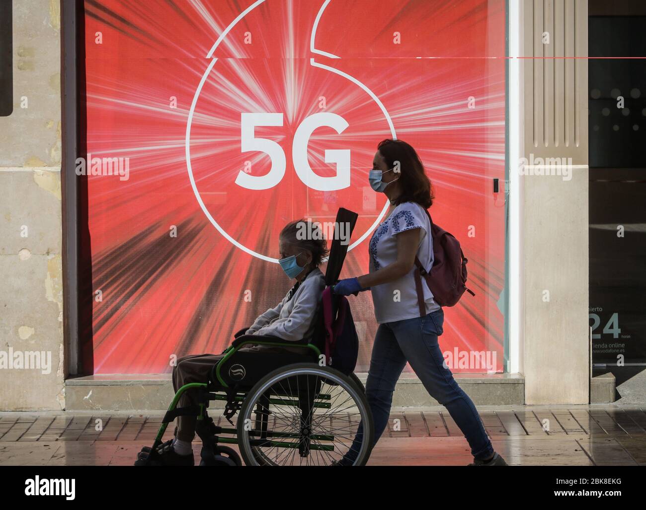 May 2, 2020: May 2, 2020 (Malaga) people walk with mask in front of a 5 G mobile poster Credit: Lorenzo Carnero/ZUMA Wire/Alamy Live News Stock Photo