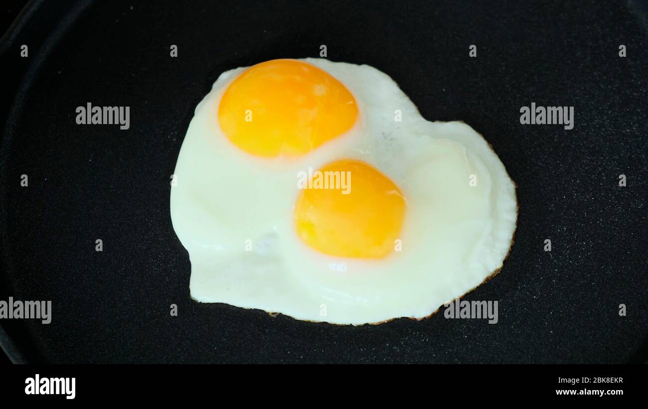 Cooking Fried eggs in pan on stove. Close up Stock Photo Alamy