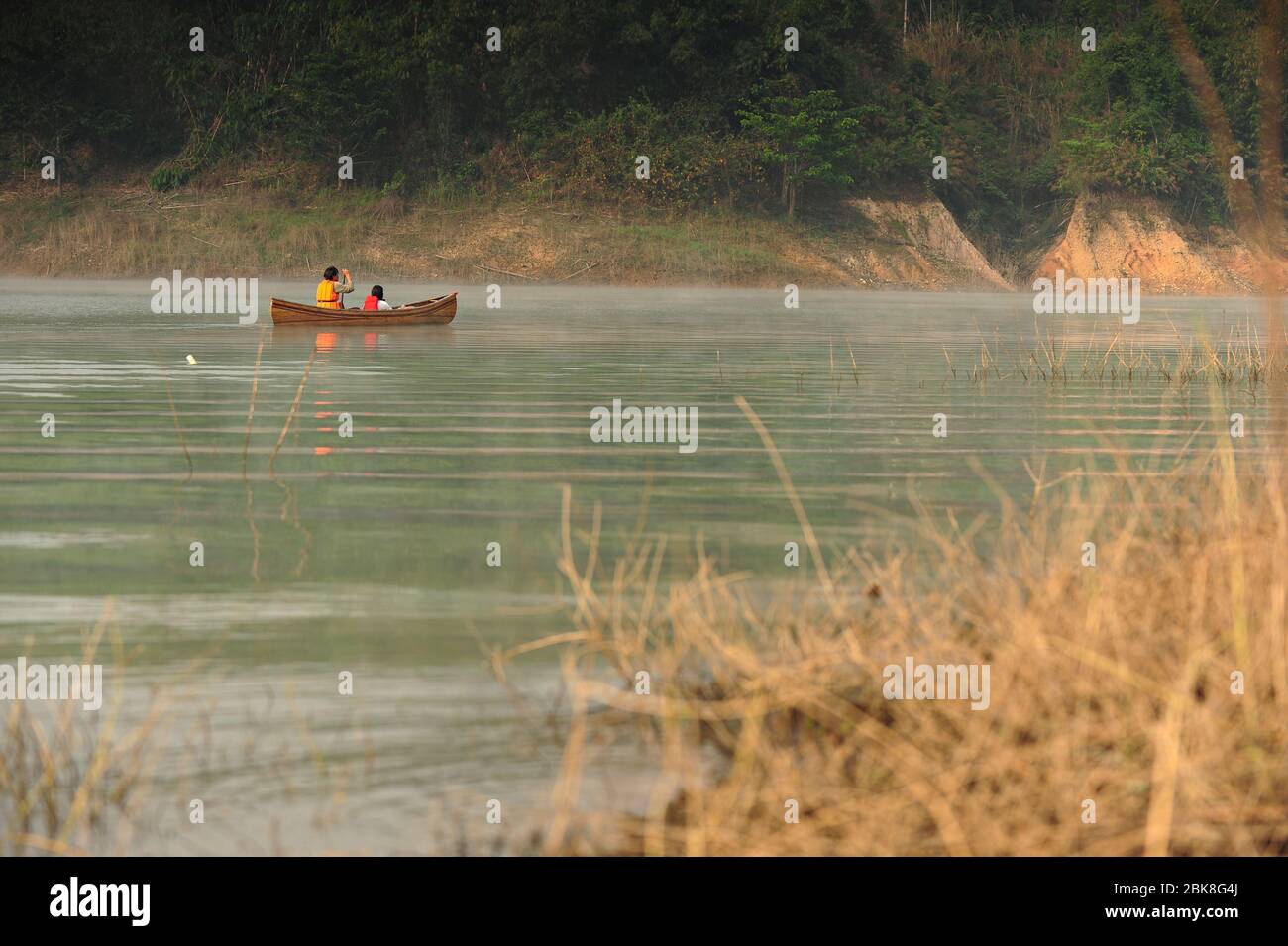 Men and women rowing wooden boat admiring the beauty of nature Khao Laem Dam Kanchanaburi, Thailand Stock Photo