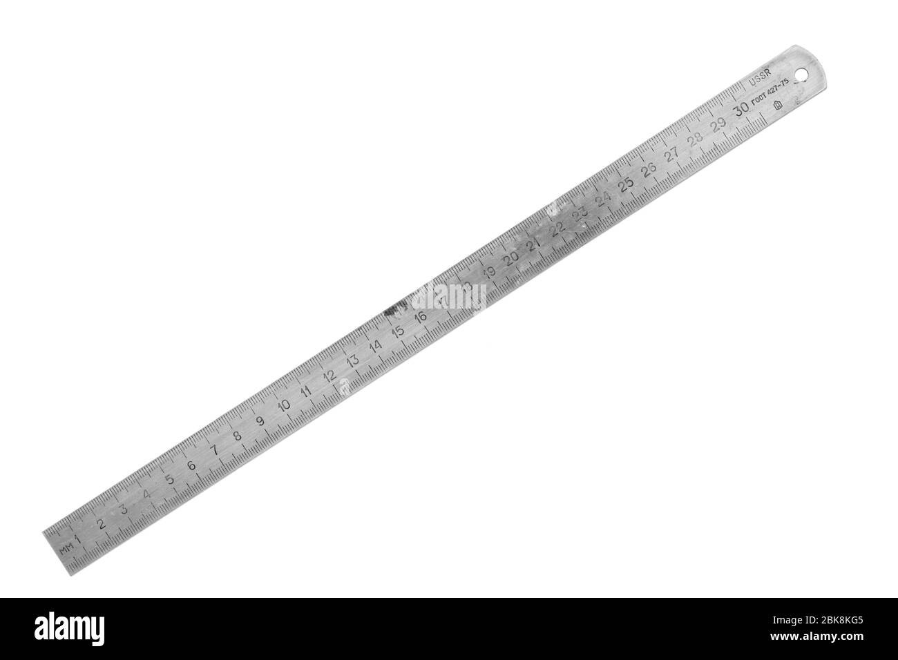 Old metal ruler isolated on white background. Measuring equipment Stock Photo