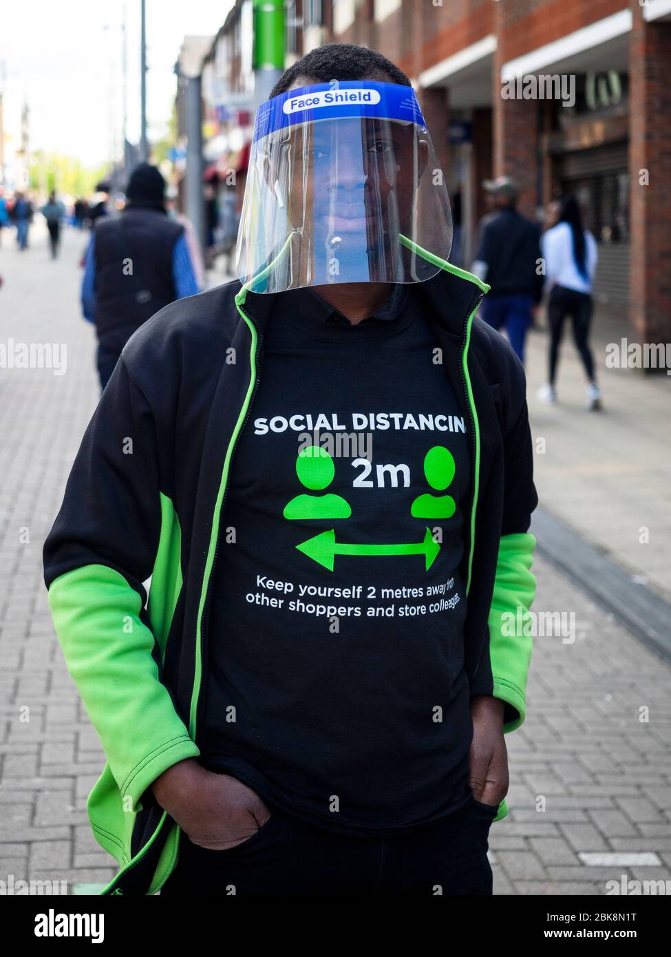 Walthamstow. London. UK. May the 2nd, 2020. Close-up of Essential Worker with face shield and social distancing t-shirt. This guy works in Asda Superm Stock Photo
