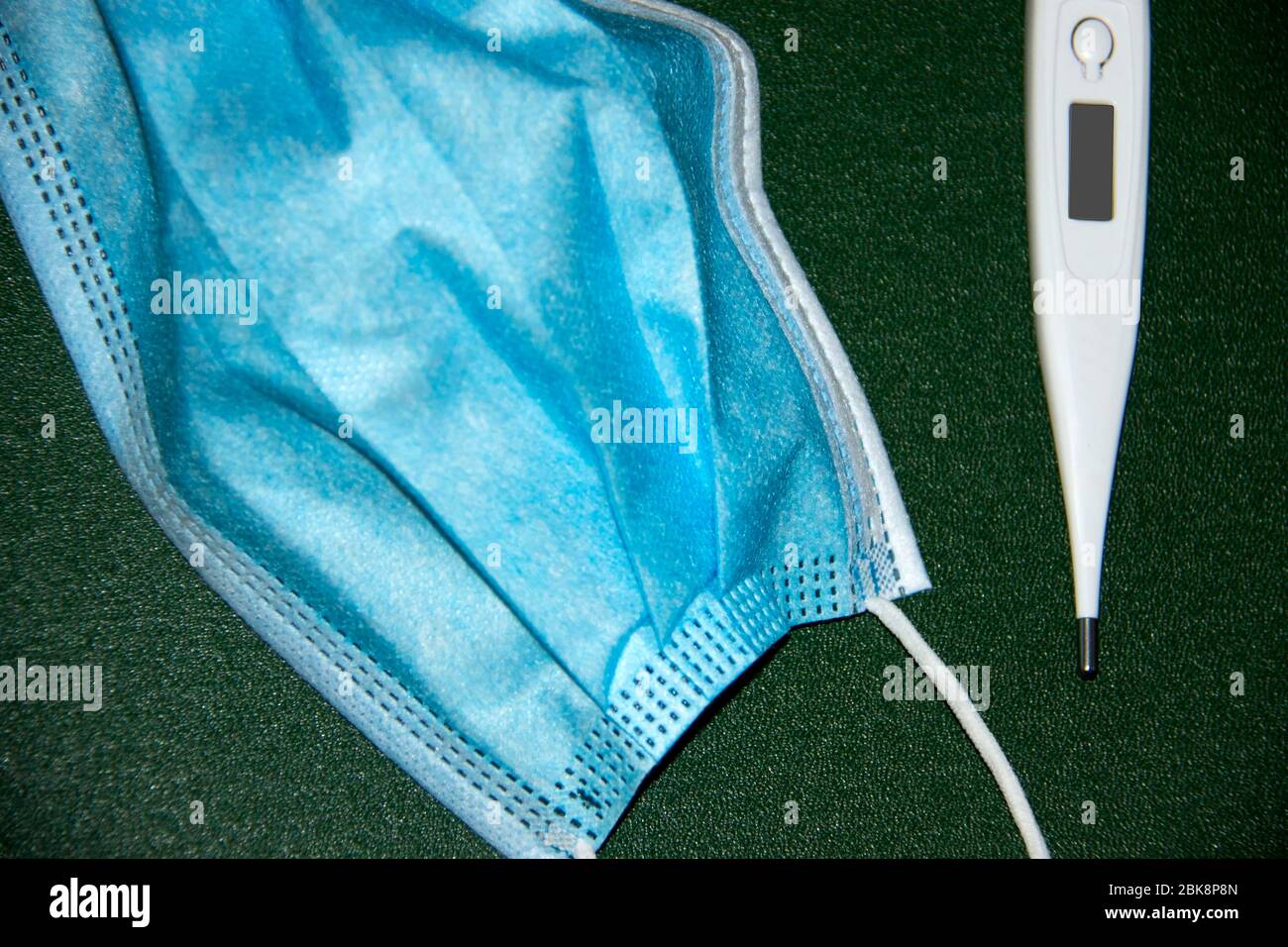 Medical face mask and thermometer Stock Photo