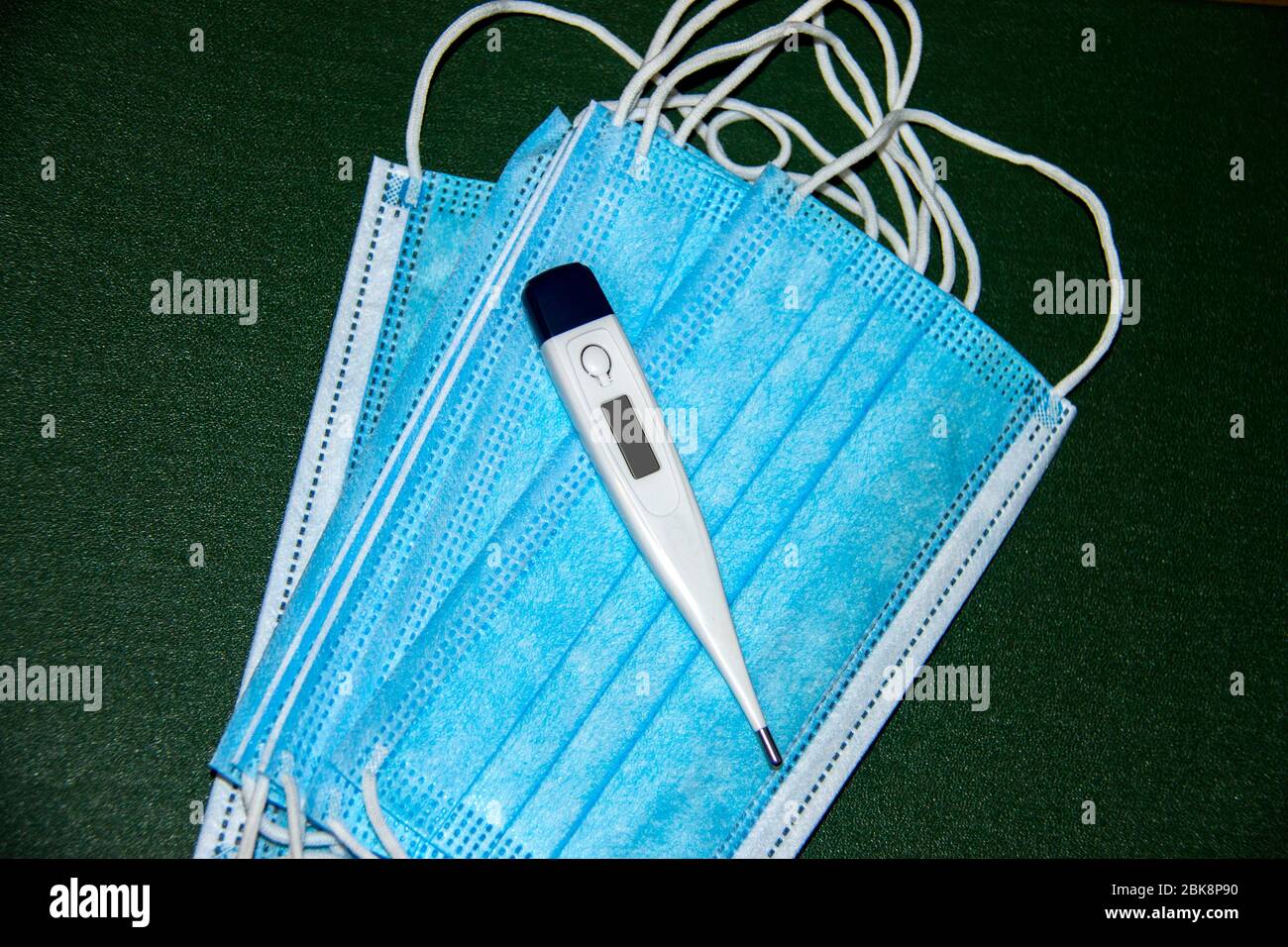 Medical face mask and thermometer Stock Photo