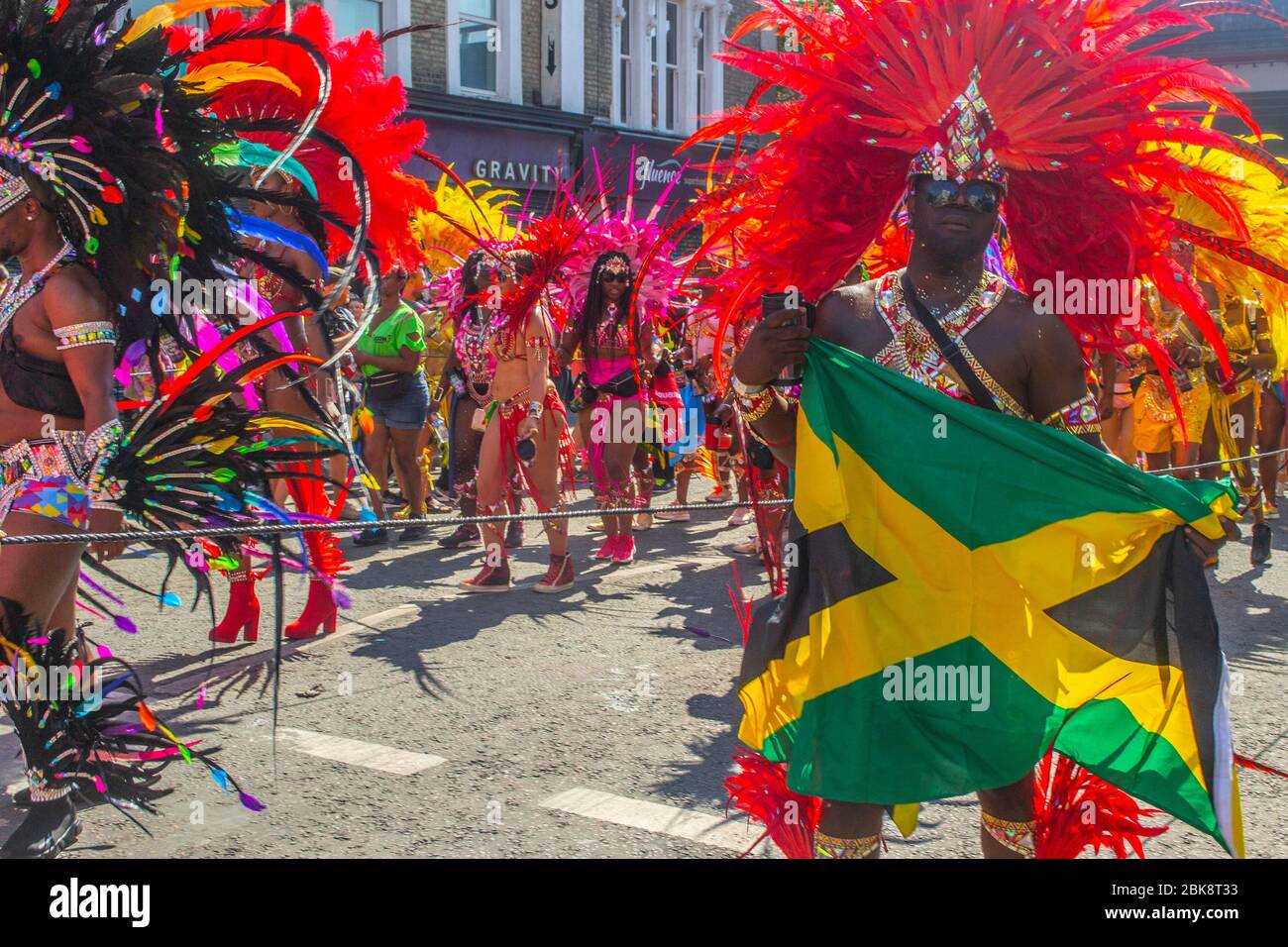 London / United Kingdom - August 26th 2019: Man in a samba outfit dancing with a Jamaican flag at the 53rd edition of Notting Hill Carnival 2019 Stock Photo