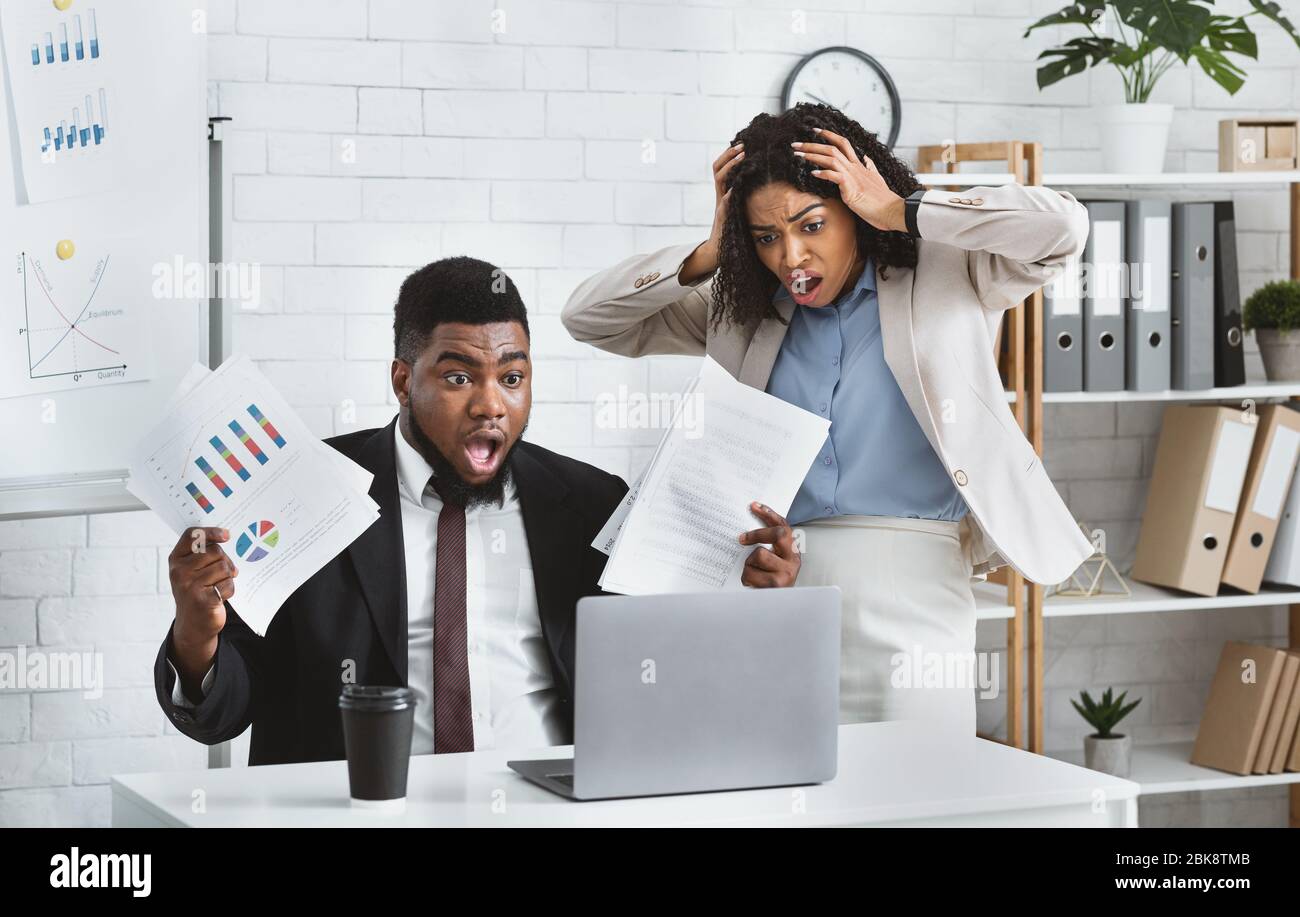 Stressed African American colleagues missing project deadline at office Stock Photo