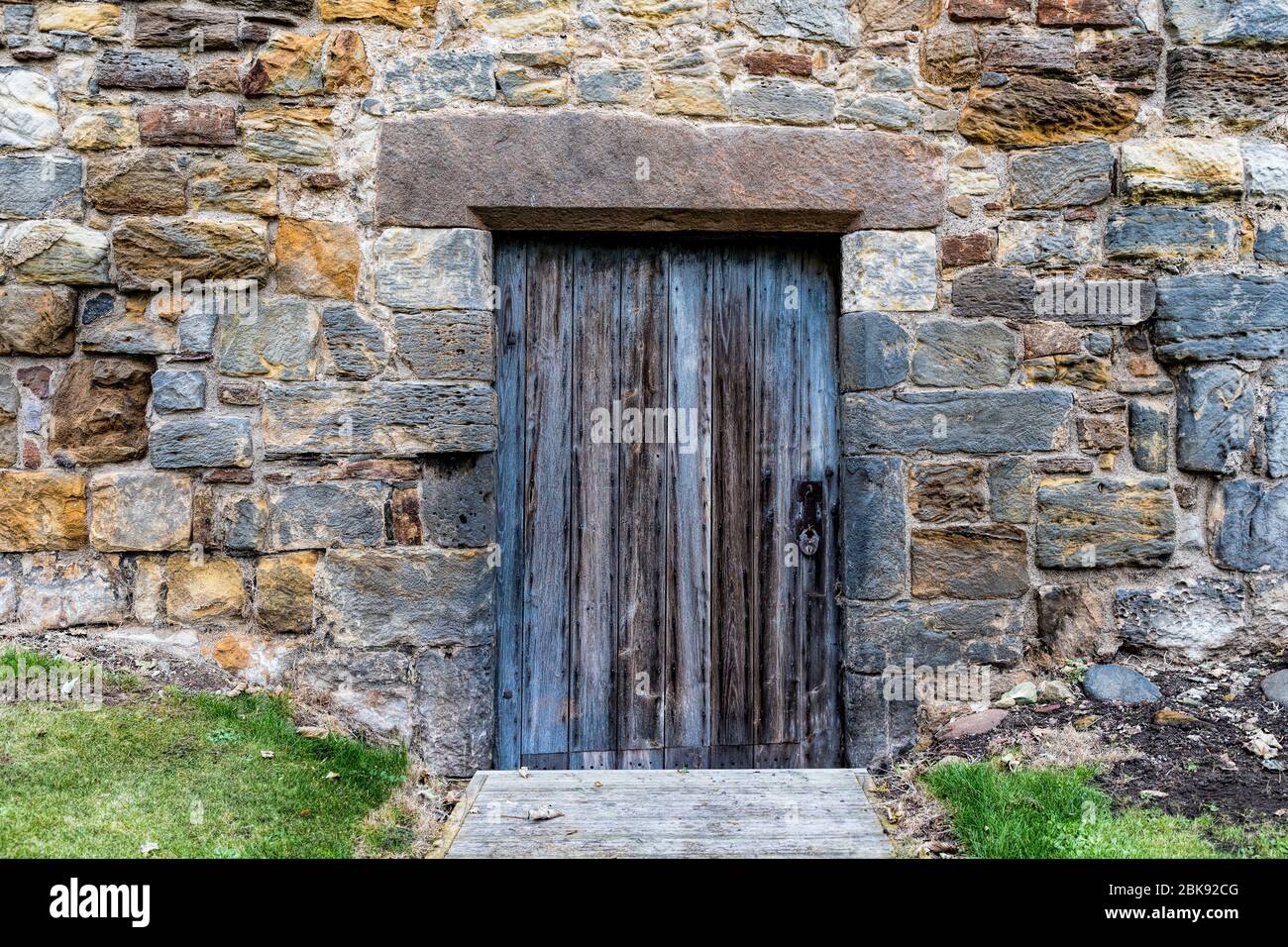 Old wooden door set in a stone wall of a castle Stock Photo - Alamy
