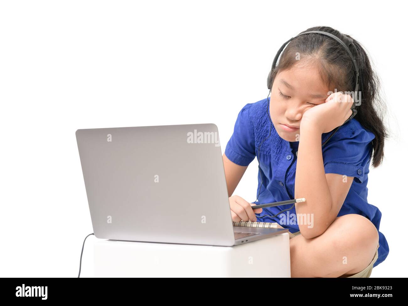 Coronavirus Outbreak. Lockdown and school closures. School girl watching online education classes feeling bored and depressed at home. COVID-19 pandem Stock Photo