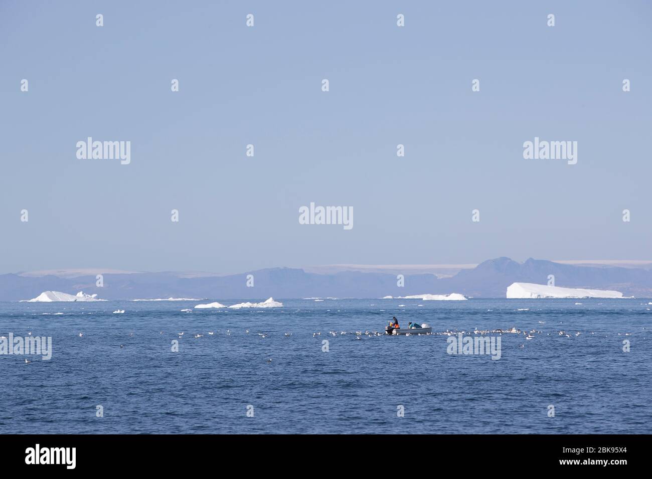 Fishing amongst icebergs, Greenland Stock Photo
