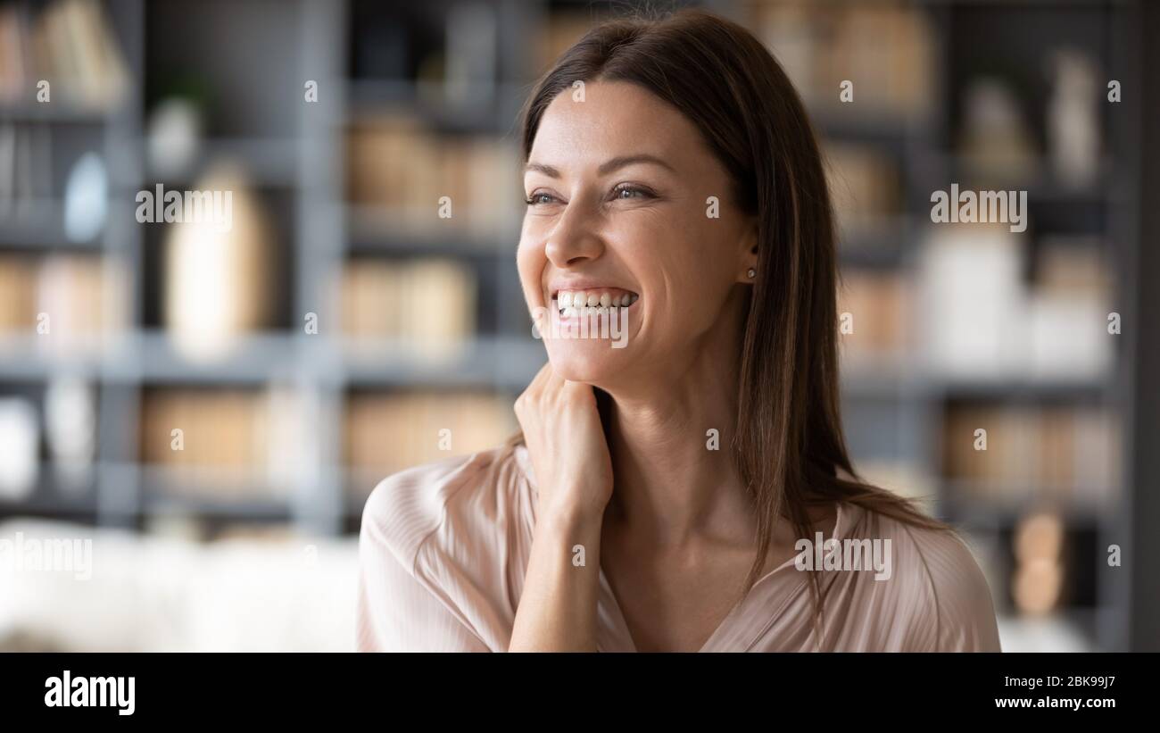 Close up smiling young woman dreaming, thinking about good future Stock Photo
