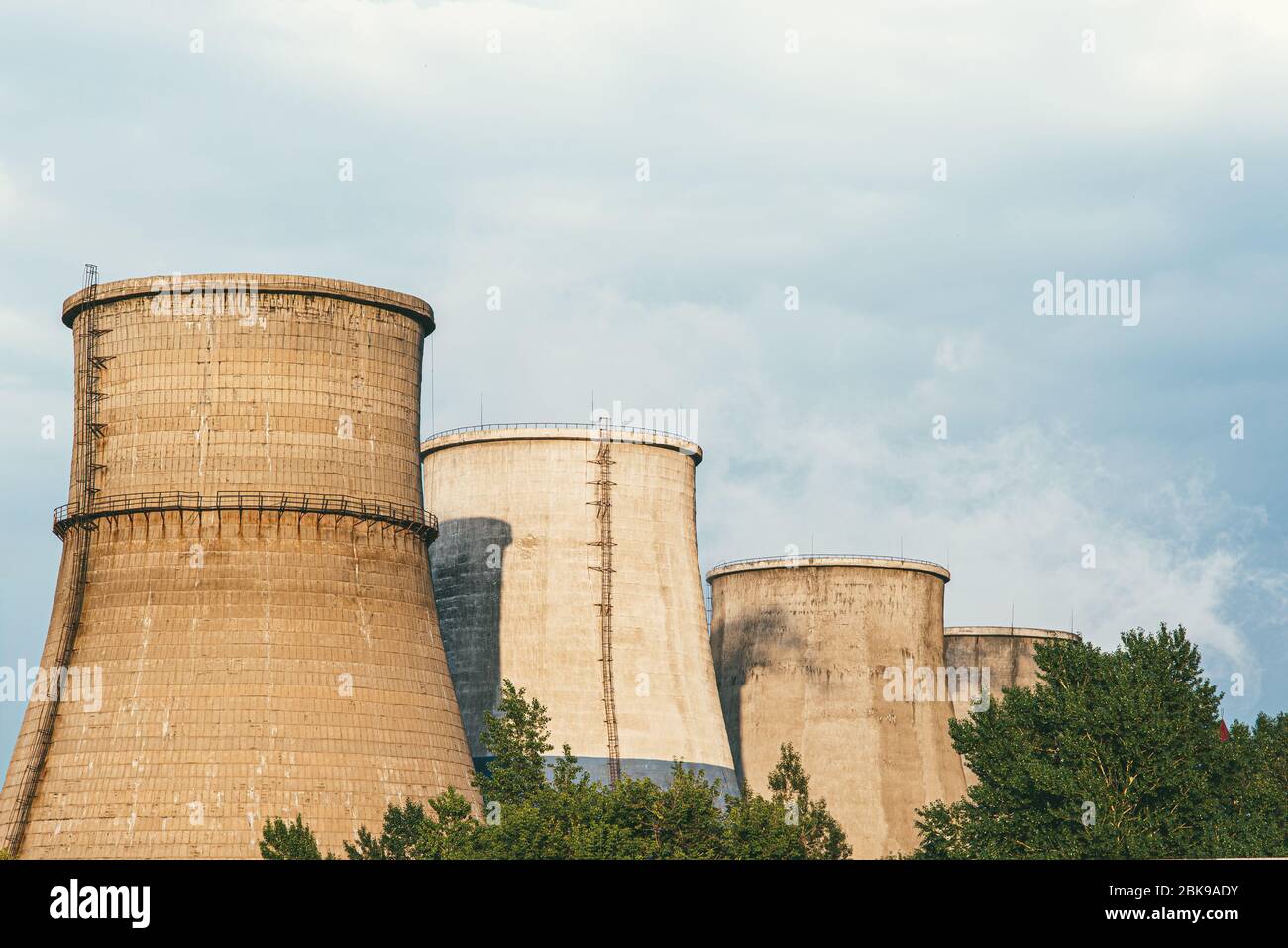 The factory releases smoke into the sky from pipes polluting the atmosphere Stock Photo