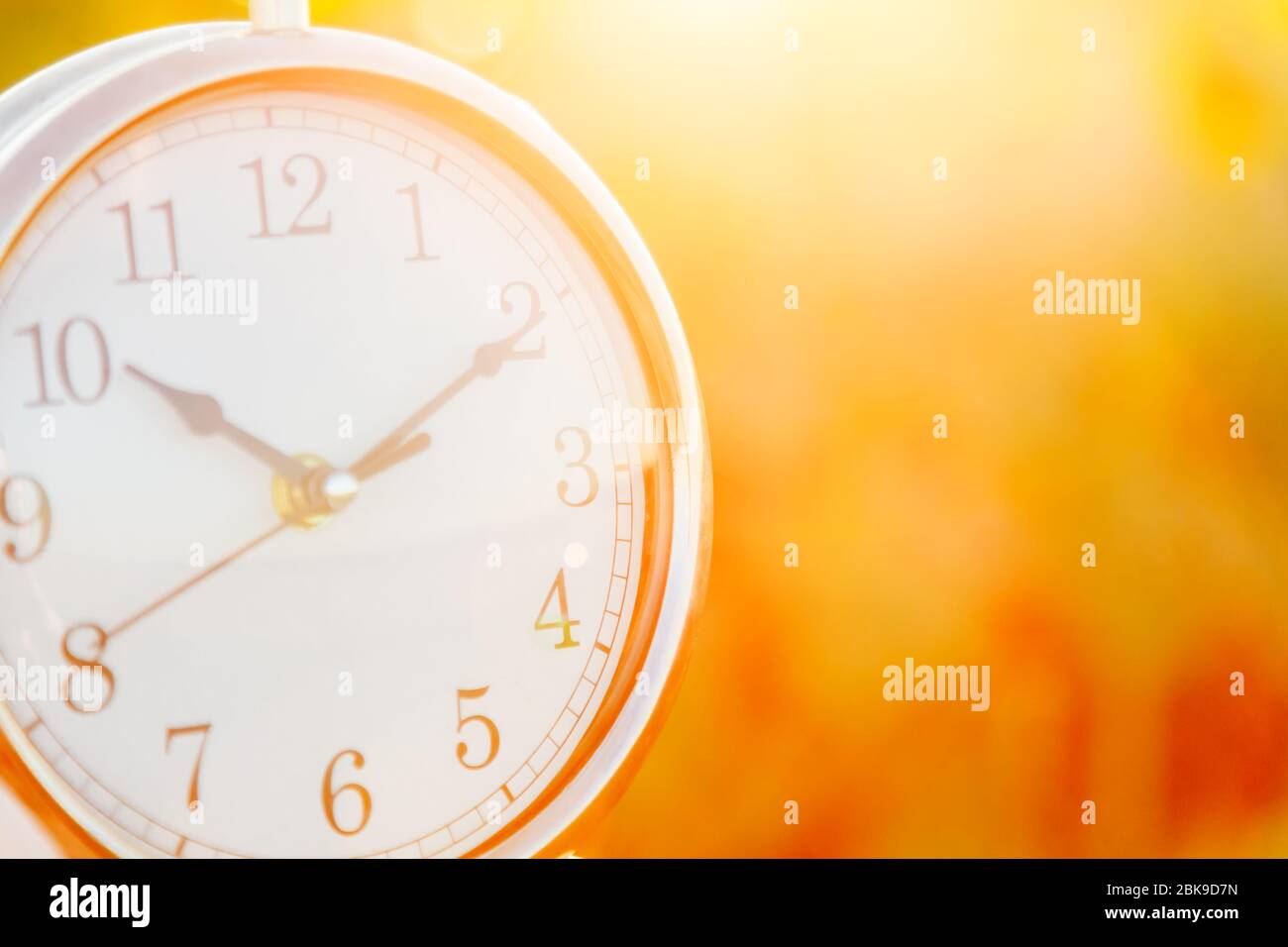 Clock on a sunset background close up. Blurred Stock Photo - Alamy