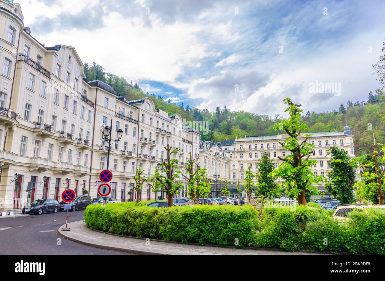 Karlovy Vary, Czech Republic, May 11, 2019: Grandhotel Pupp building in Carlsbad historical city centre, Slavkov Forest hills with green trees background, West Bohemia Stock Photo