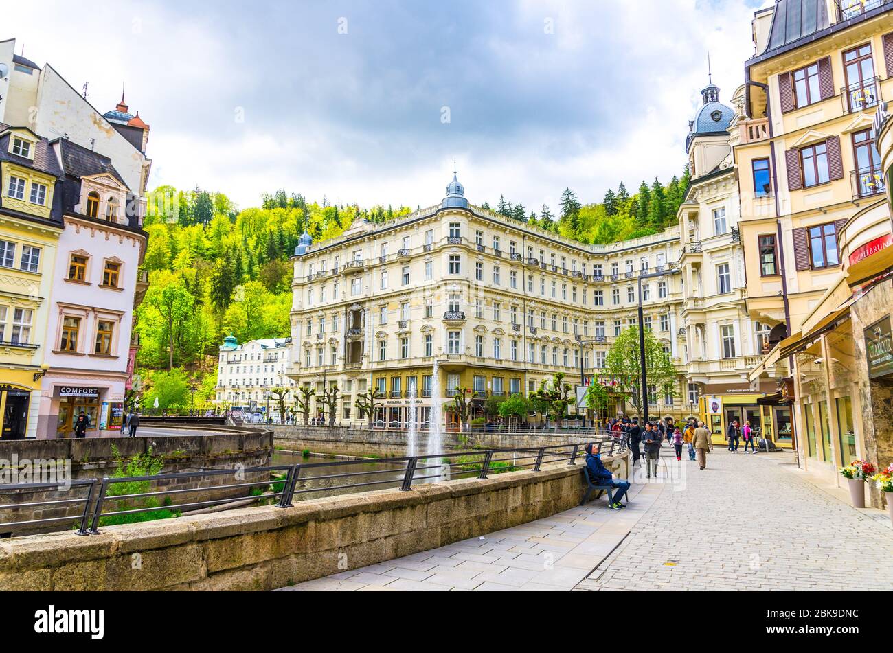 Karlovy Vary, Czech Republic, May 9, 2019: Carlsbad historical city centre with Tepla river central embankment, Grandhotel Pupp building, Slavkov Forest hills green trees background, West Bohemia Stock Photo