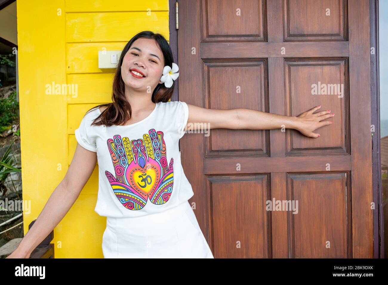 Thai young girl posing smiling in front of the door Stock Photo
