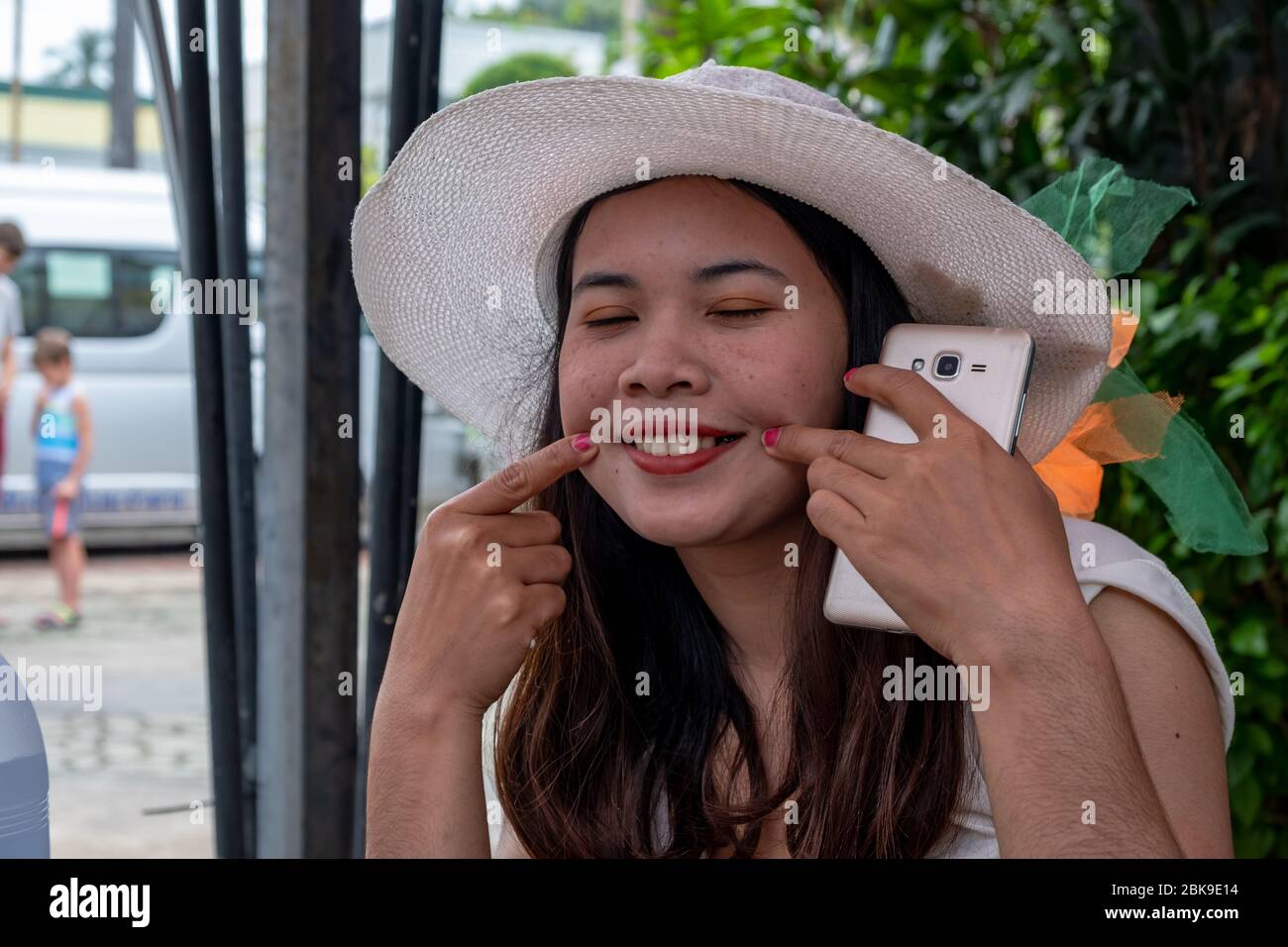 Thai lady sitting in a coffee shop and make smiling face. Stock Photo