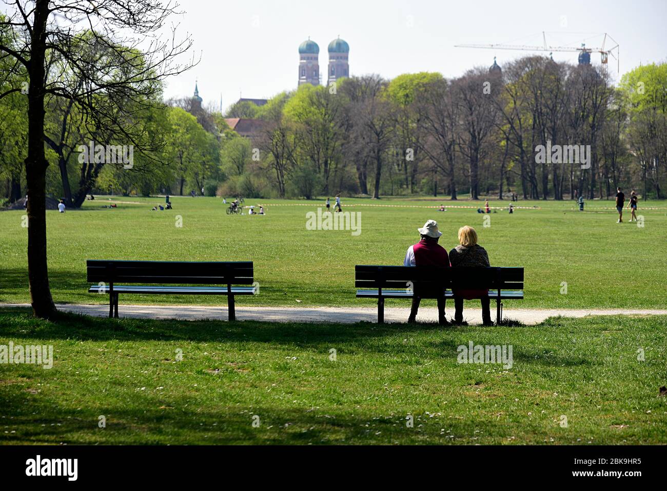 Couple sitting on a bench in the English Garden, Coronakrise Munich, Upper Bavaria, Bavaria, Germany Stock Photo