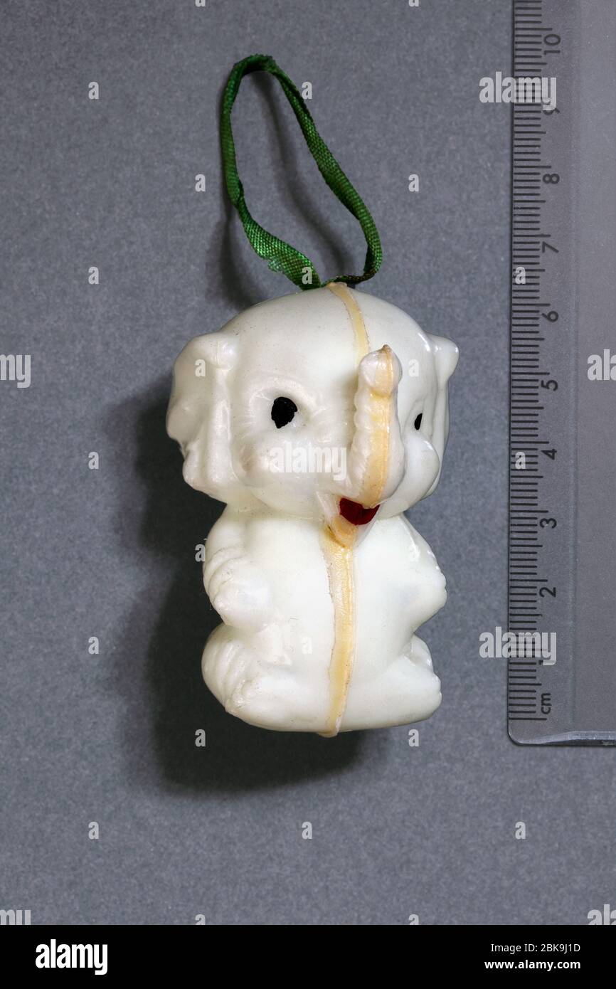 A hollow plastic trinket resembling an elephant coated with phosphorescent paint which makes it glow in the dark. See 2BK9J4D for photo of it glowing. Stock Photo