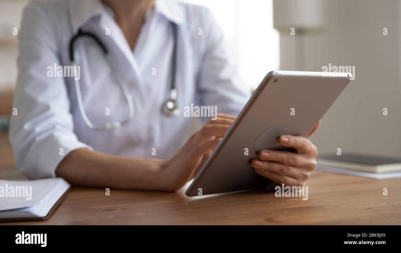 Female doctor holding using modern digital tablet, close up view Stock Photo