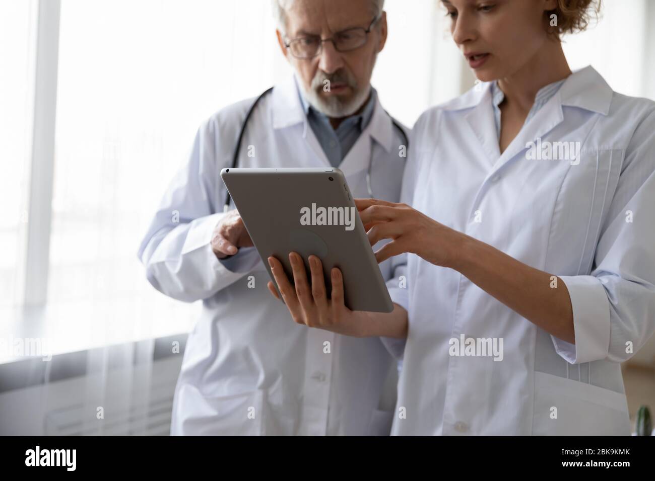 Two serious doctors discussing data using digital tablet Stock Photo