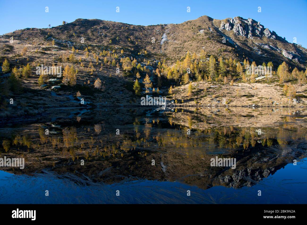 Herbstlicher Fernblick rund um den Bergsee Salei mit seinen verfärbten Lärchen im Tessiner Onsernonetal Stock Photo