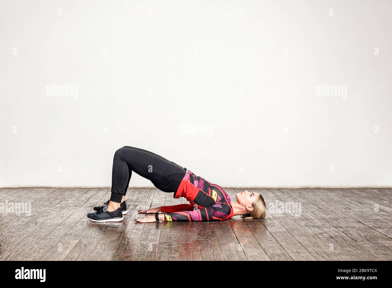 Athletic woman in tight sportswear practicing yoga, doing bridge pose bending back, stretching body, training flexibility, muscle strength. Health car Stock Photo