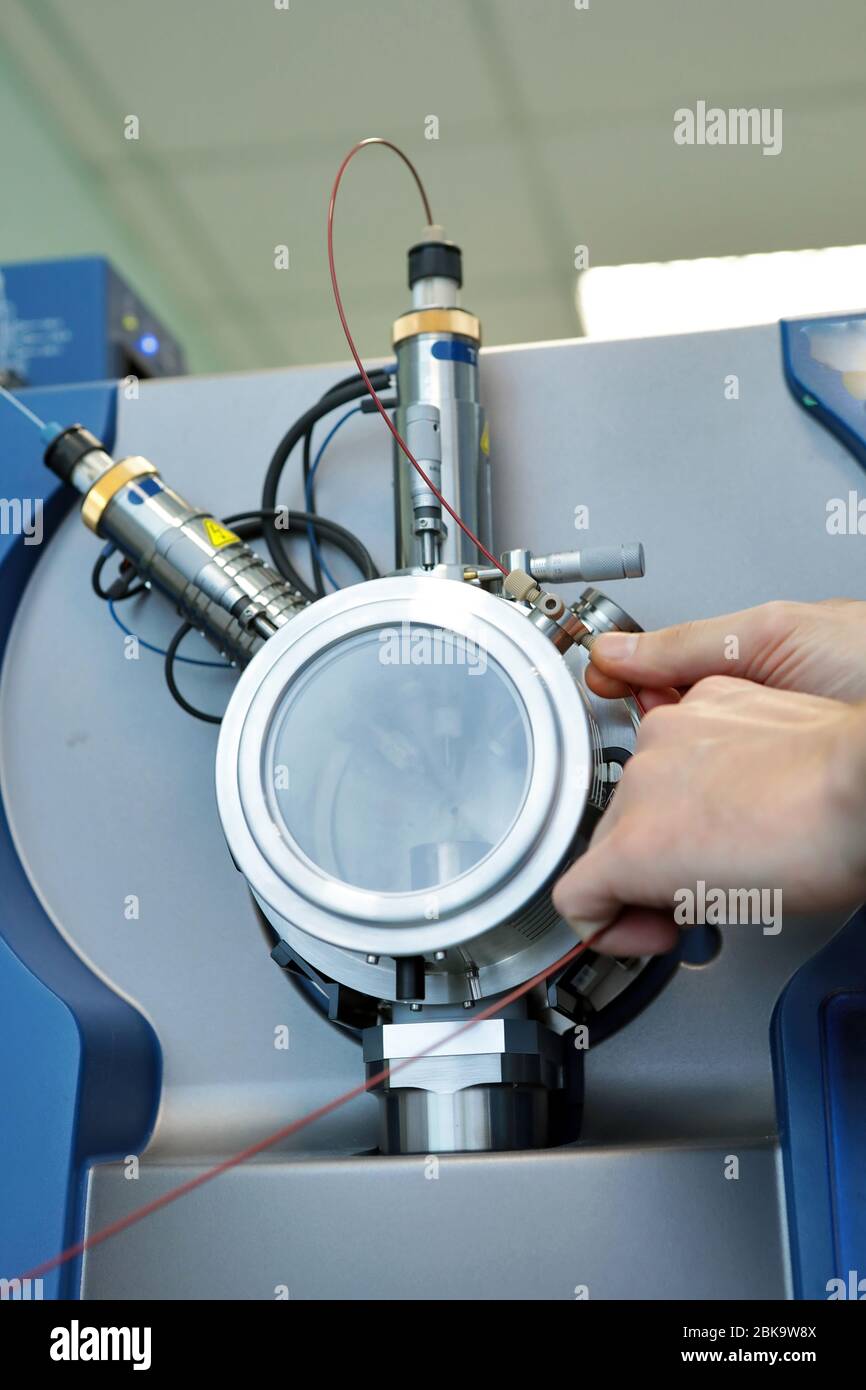 Adjust the mass spectrometer. The man analyzes the device for determining the masses of atoms. Device for the pharmaceutical industry. Ionic source of Stock Photo