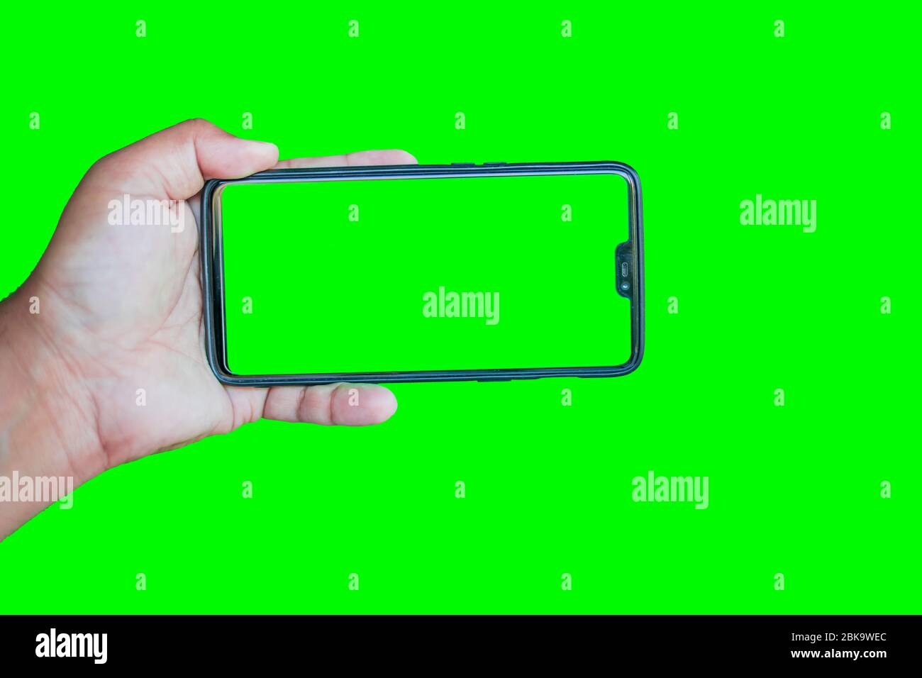 Man holding phone with chroma key display against the green screen  background Stock Photo - Alamy