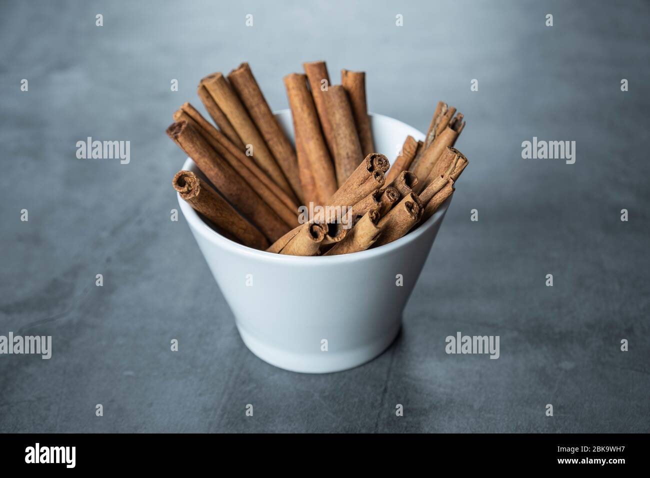 Cinnamon sticks in white porcelain bowl. Stock Photo