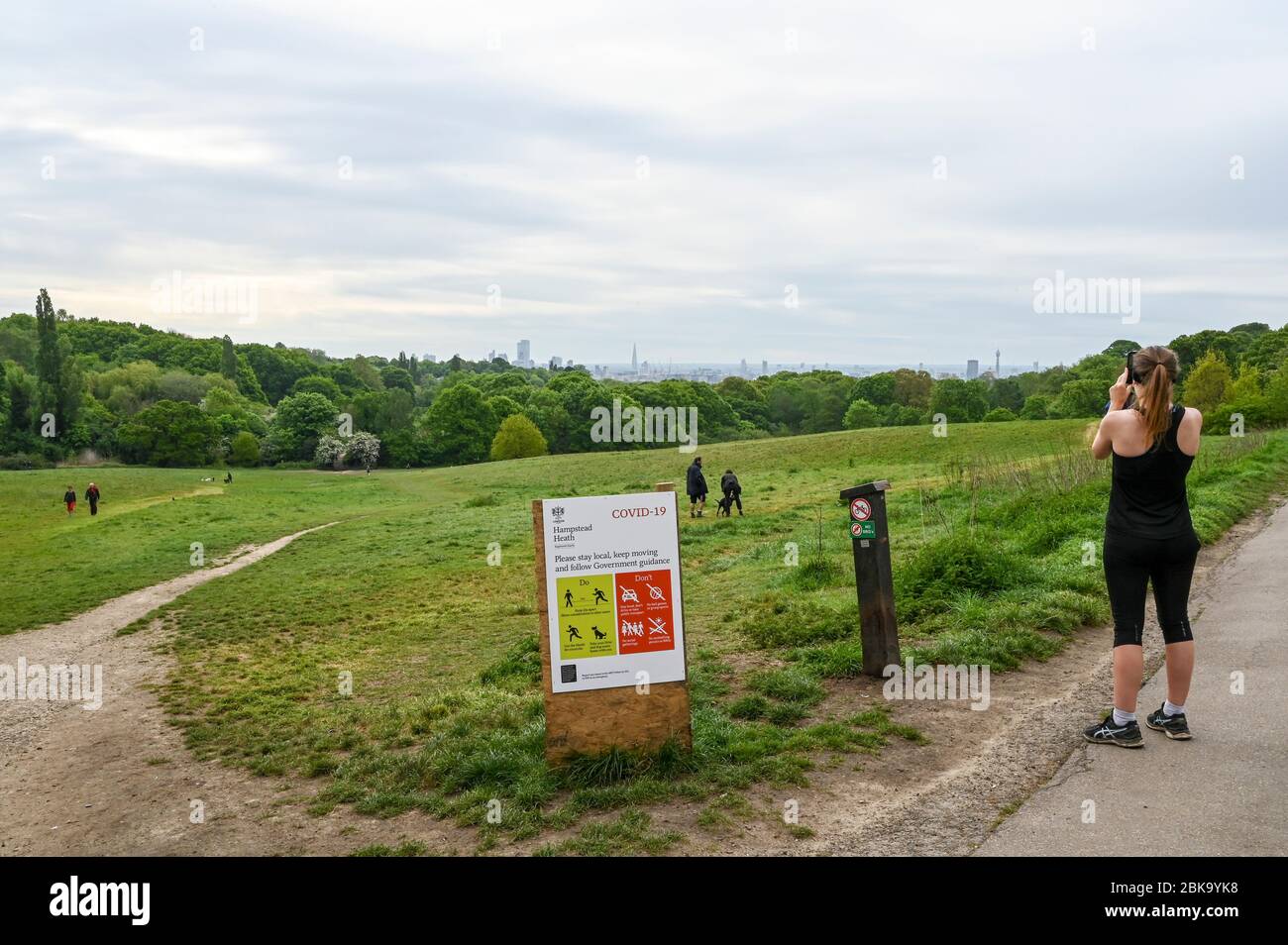 Hampstead Heath and London skyline, with illustrated instructions during the Covid-19 pandemic. People walk and run observing social distancing. Stock Photo