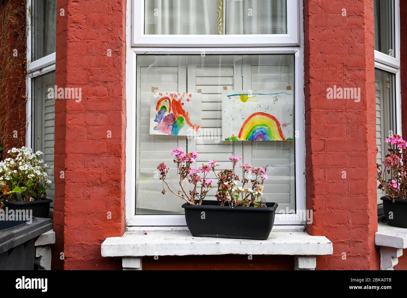 Colourful paintings of rainbows by children displayed in windows to ...