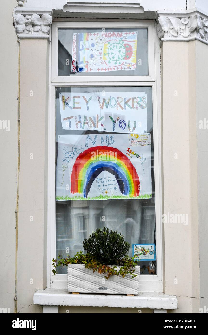 Colourful paintings of rainbows by children displayed in windows to ...