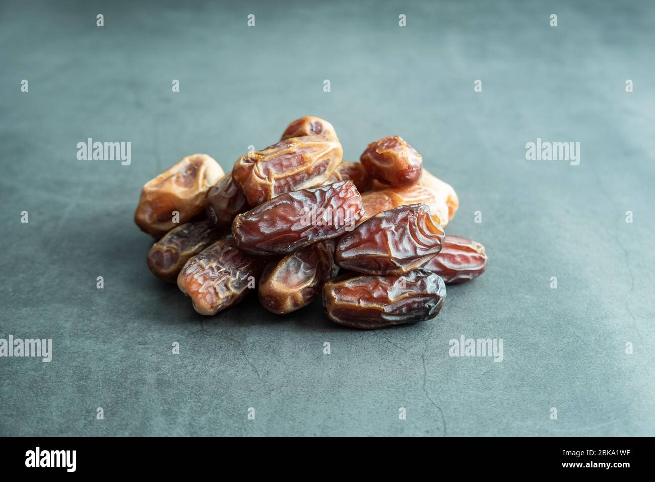 Raw date fruit ready to eat on concrete background. Traditional, delicious and healthy ramadan food. Stock Photo