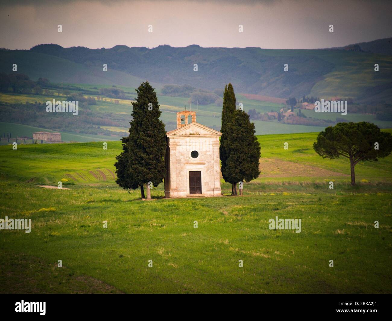 Tuscany at sunset with chapel of Madonna di Vitaleta, San Quirico d'Orcia, Italy. Stock Photo