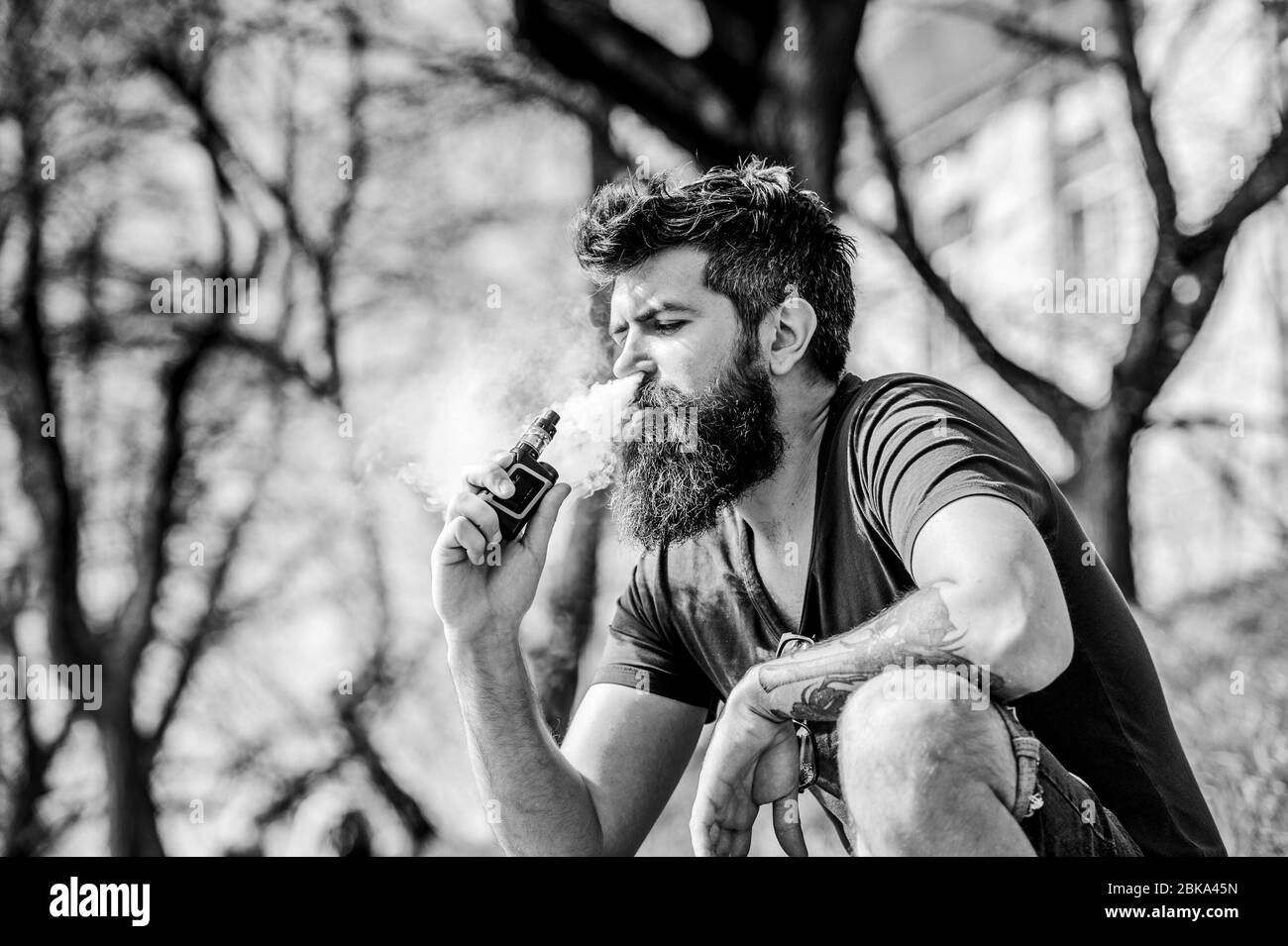 Perfect style. Health safety and addiction. inhaling vapor. man smoking e-cigarette. Mature hipster with beard. Bearded brutal male smoking electronic cigarette. hipster man hold vaping device. Stock Photo