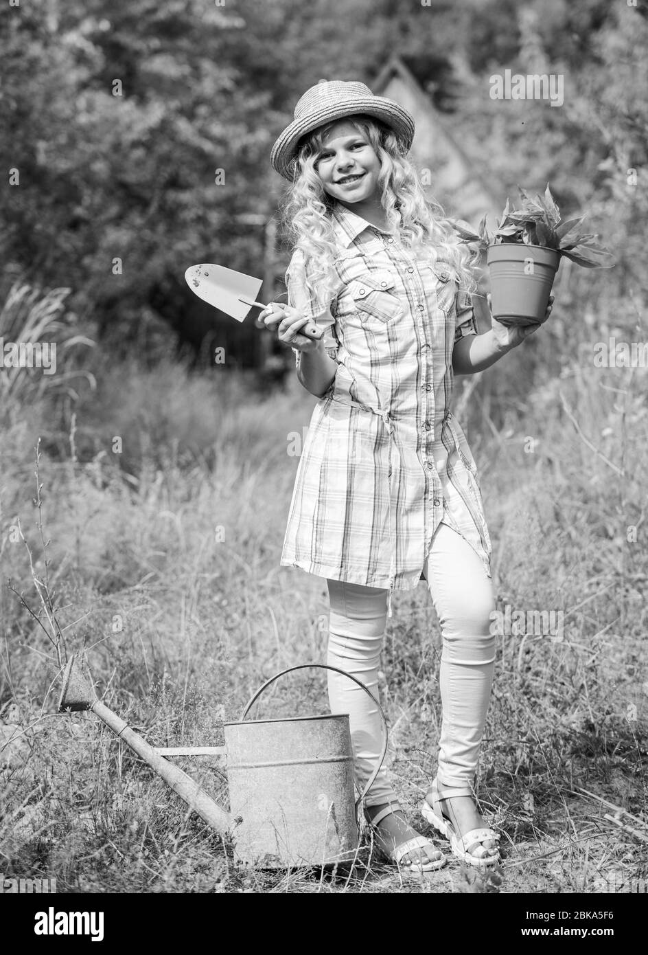 Ranch girl. Happy childhood. Planting plants. Little kid hold flower