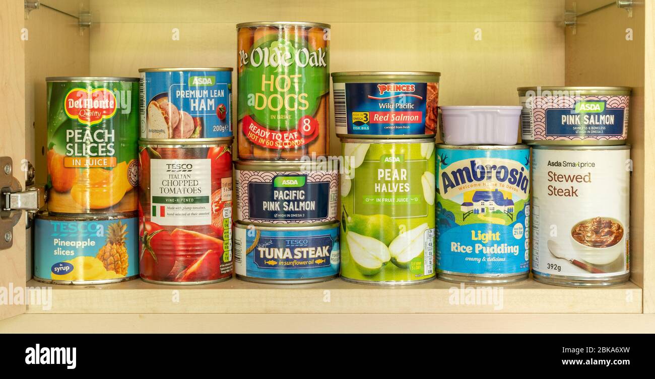 Tinned food (canned food) in a kitchen store cupboard. Tins, cans. Stock Photo