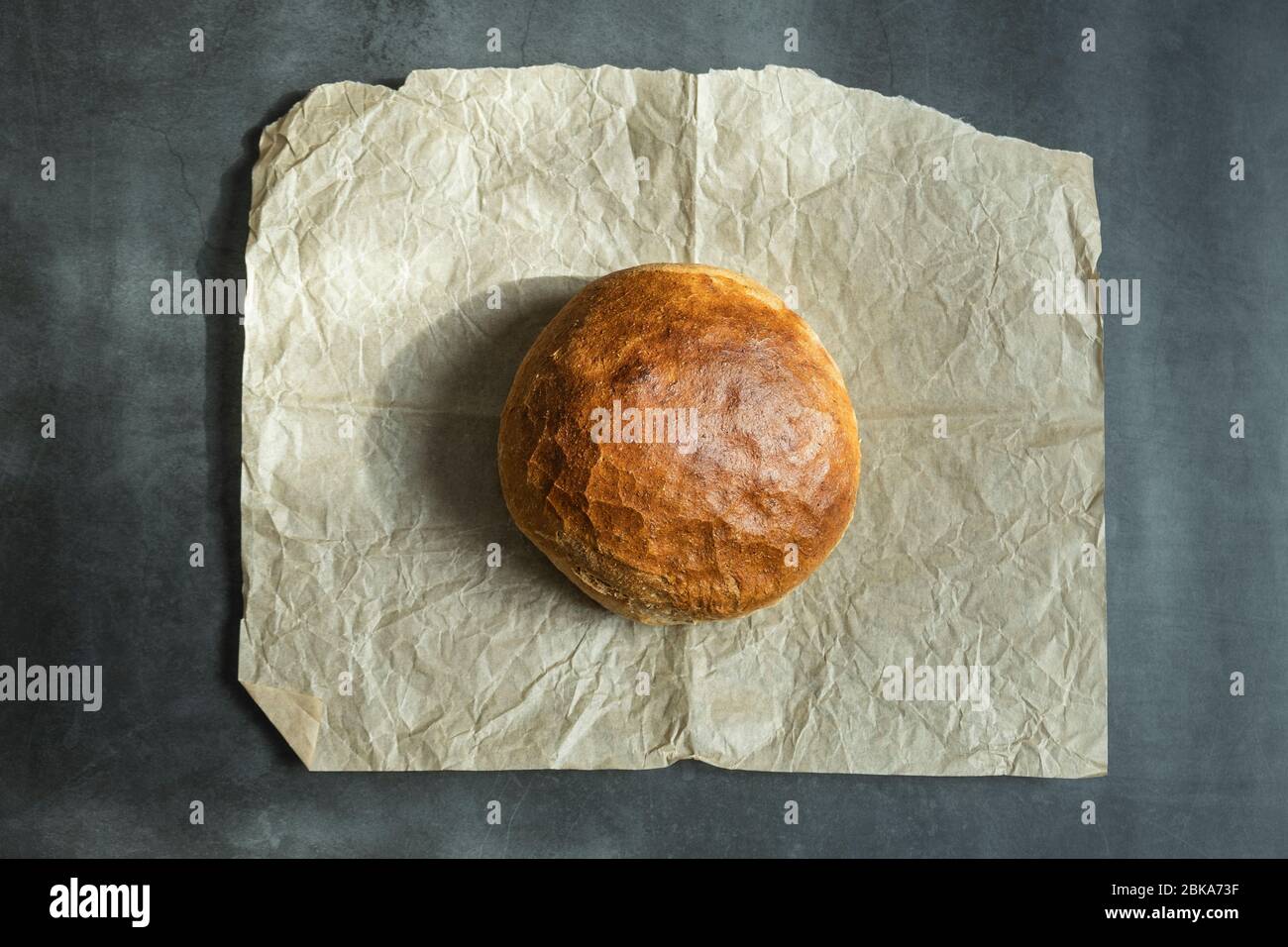 Fresh baked round bread on baking paper. Healthy, delicious and ...
