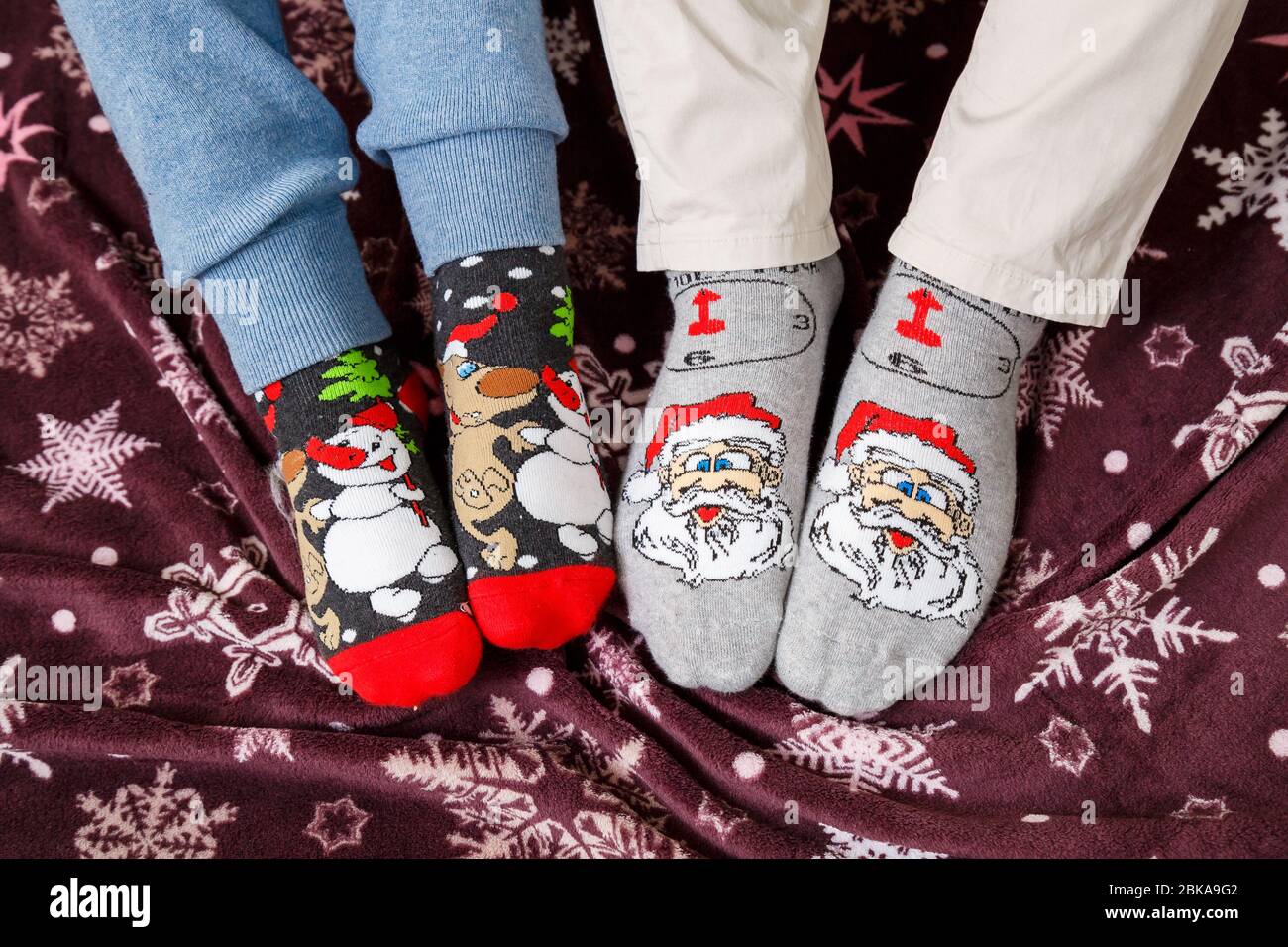 Couple relax. Two pair of feet in colorful ornamented Christmas socks over  blurred Xmas room background, selective focus Stock Photo - Alamy