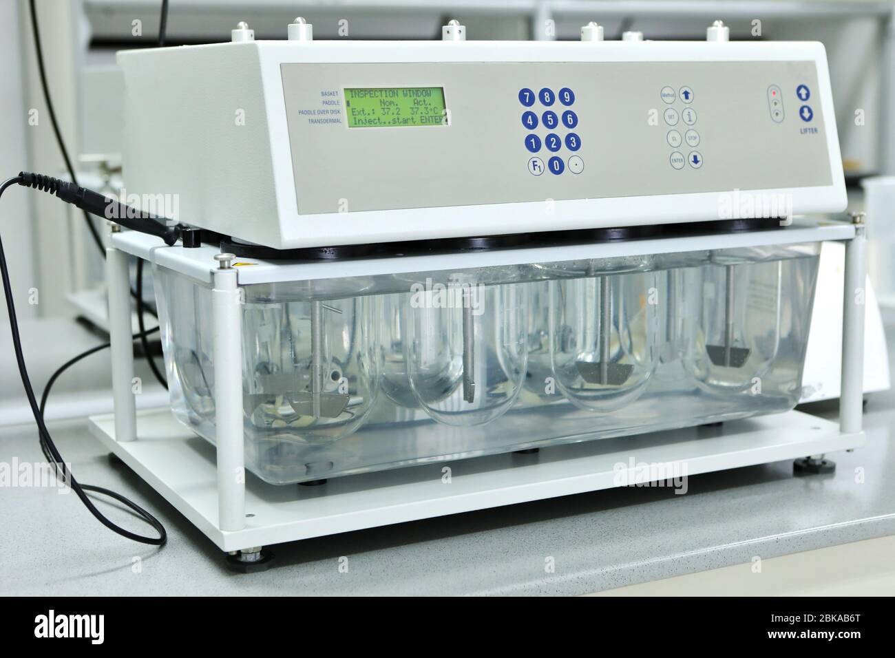 Solubility Test Lab Machine A female chemist conducts solubility tests of tablets and other dosage ...
