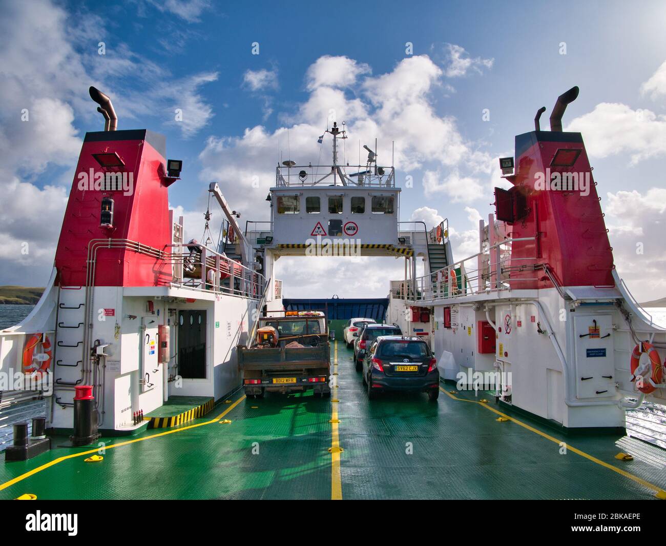 Between twin red funnels, vehicles on the car deck of the roll on/roll off car ferry from Laxo on Mainland to Symbister on Whalsay Stock Photo