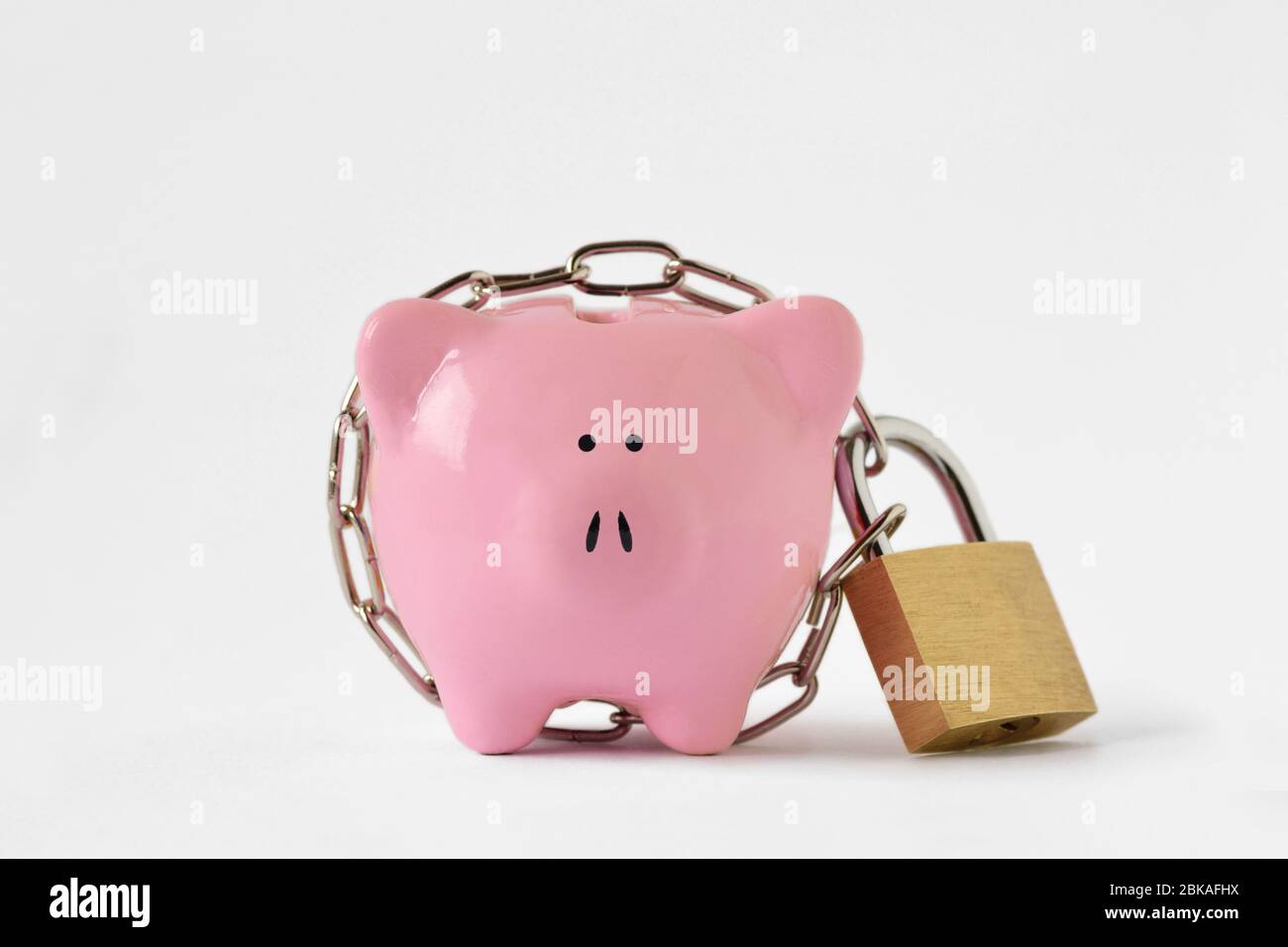 Piggy bank locked with chain and padlock on white background - Concept of savings and financial protection Stock Photo