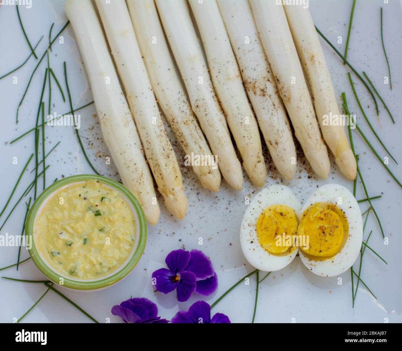 Bunch of fresh uncooked white asparagus and boiled eggs, new harvest, close up. Filter effect.  seasonal vegetables. Selective focus Stock Photo