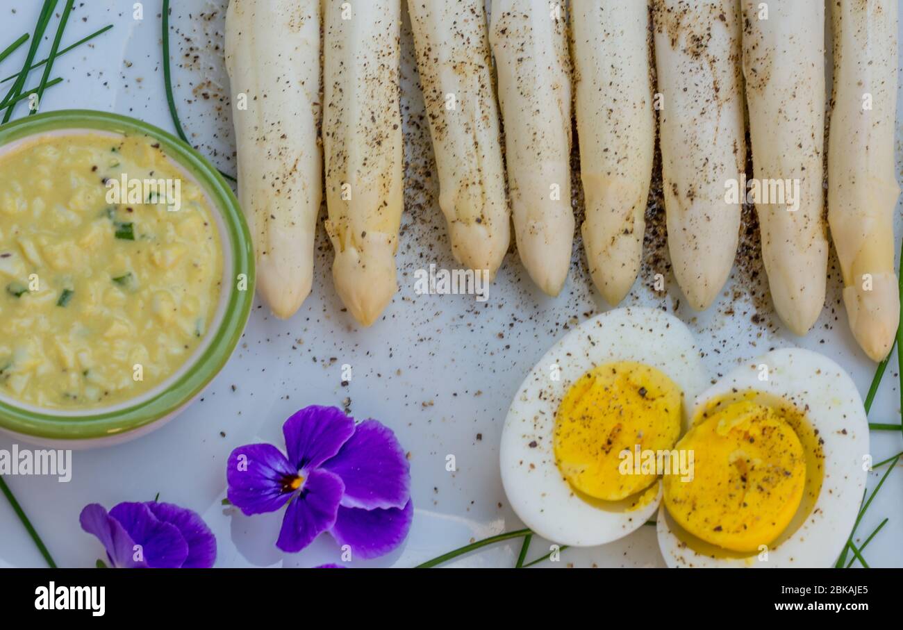 Bunch of fresh uncooked white asparagus and boiled eggs, new harvest, close up. Filter effect.  seasonal vegetables. Selective focus Stock Photo