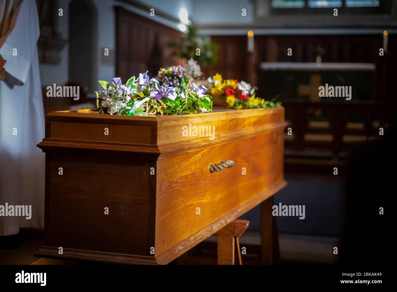 Lone coffin waits as eulogy is read at a funeral at a rural church in Southern UK February 2020 Stock Photo