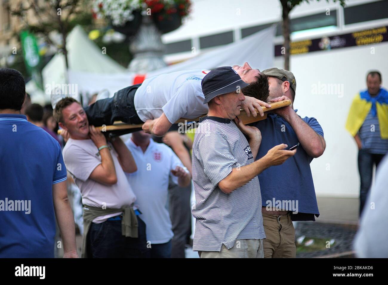 Polish soccer male fans carrying their drunk fellow on the stretcher on the  street Stock Photo - Alamy