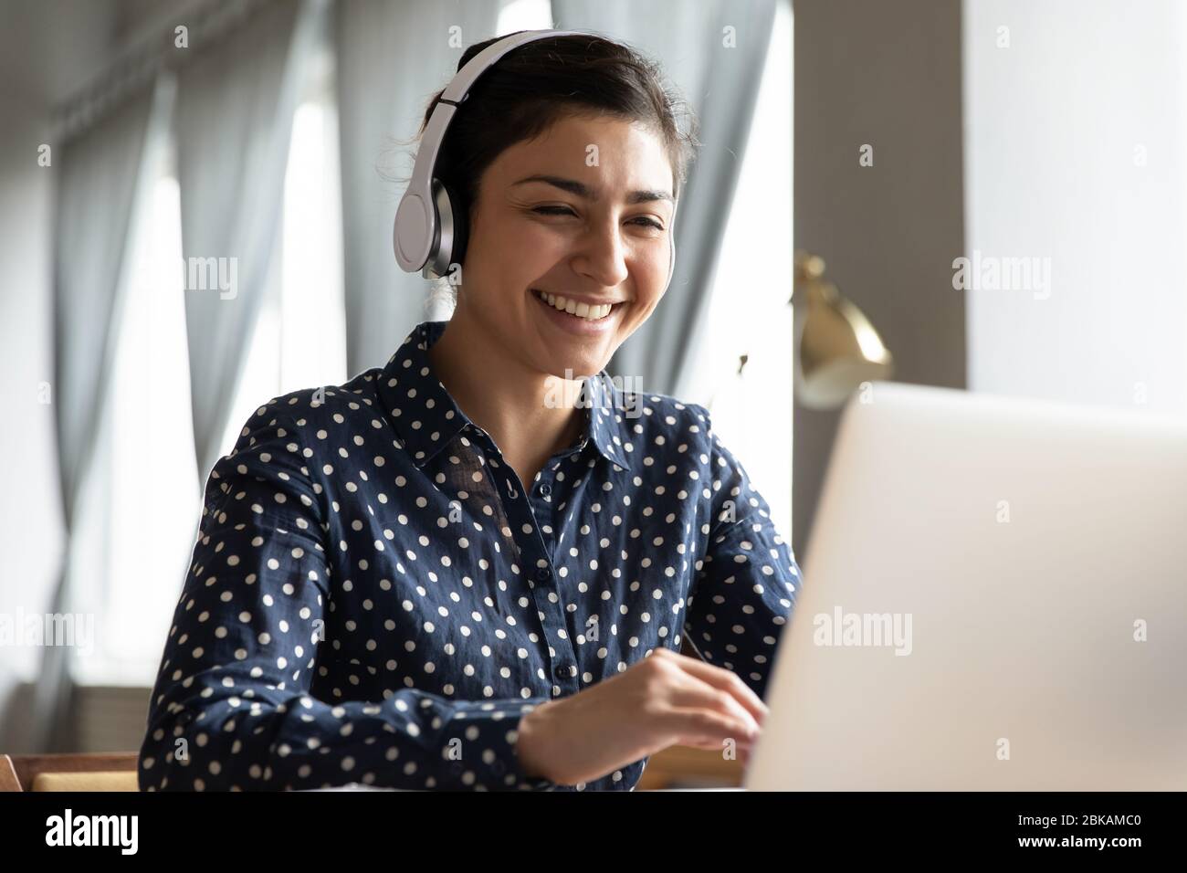 Smiling young indian student attending educational lecture online. Stock Photo