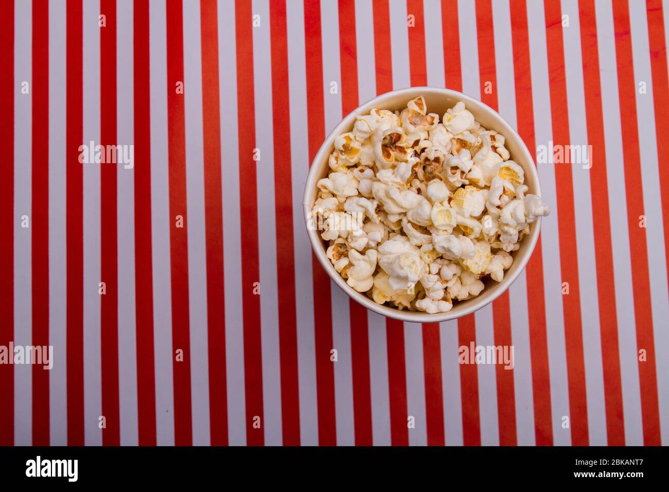 Top view of popcorn in bowl on striped background Stock Photo