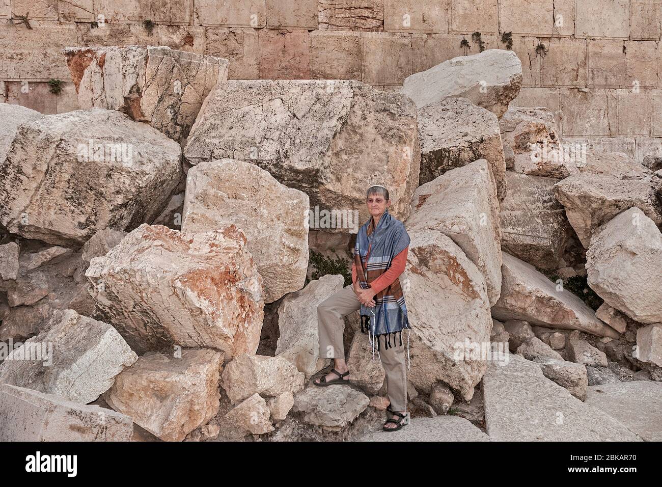 a female rabbi posing on the massive stones thrown down from the temple mount by the romans during the great jewish revolt in Jerusalem Stock Photo