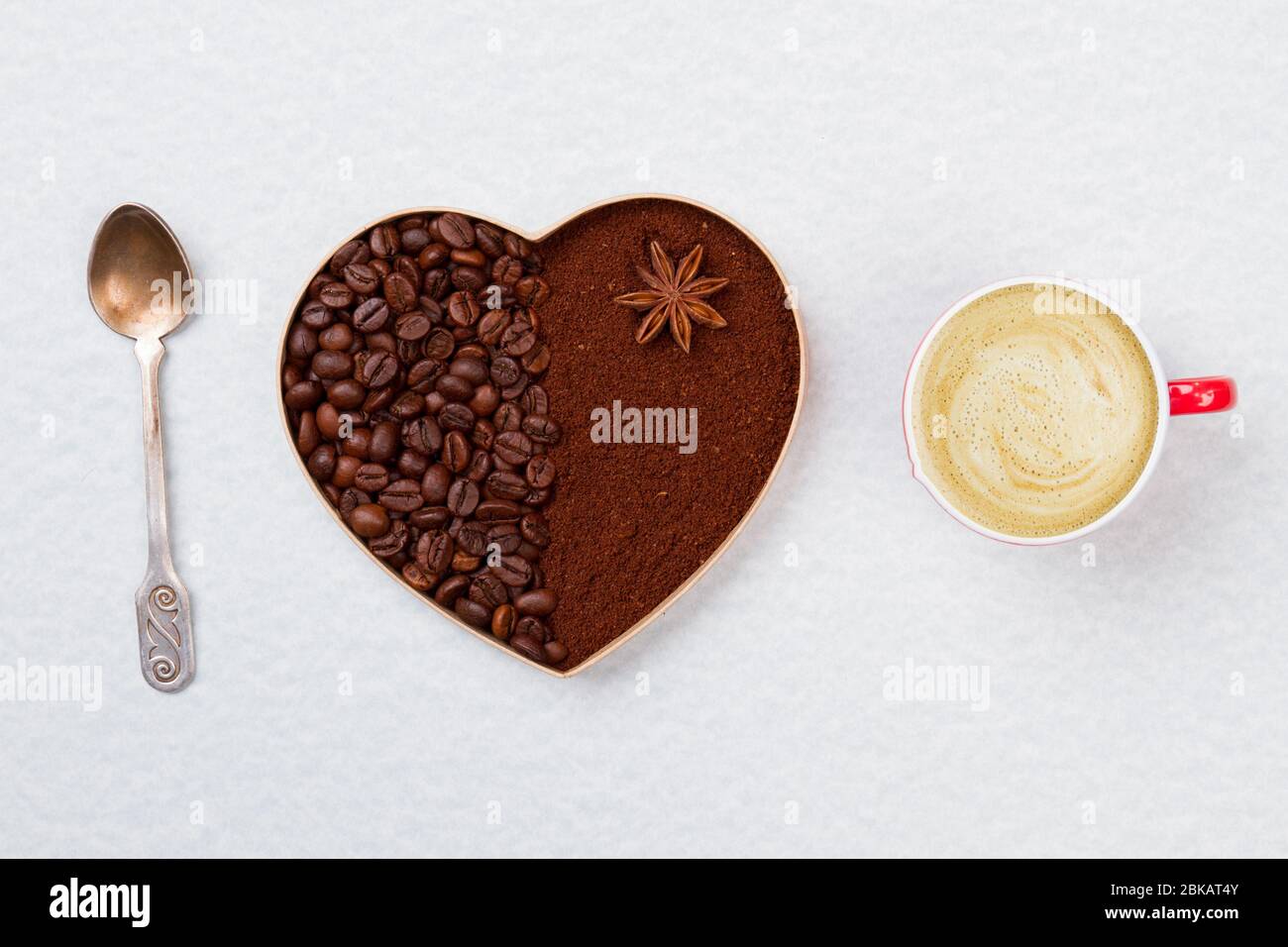 Decorative coffee heart with teaspoon and coffee mug with foam Stock
