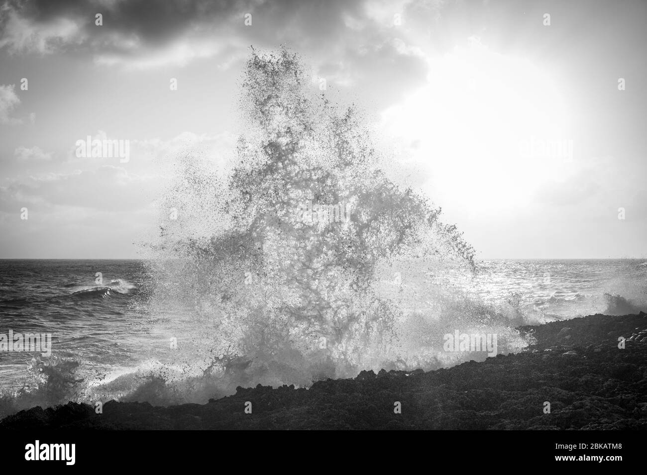 Large waves crashing against rocks at sunset, Grand Cayman Blowholes Stock Photo